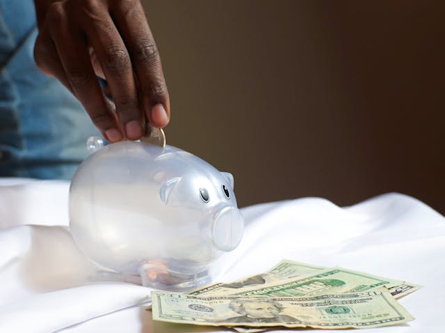 a person putting money in a piggy bank